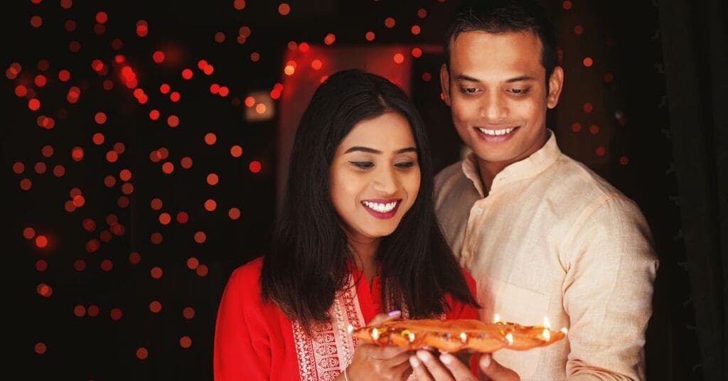 An Indian couple holding diya thali for Diwali in Canada 2025 celebration.