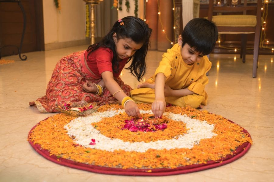 Young children making a ranjoli for Diwali in a Canadian apartment. 