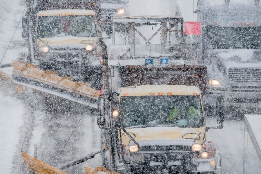 Snowplows working on a Canadian highway, and important safety consideration for newcomers driving in winter. 