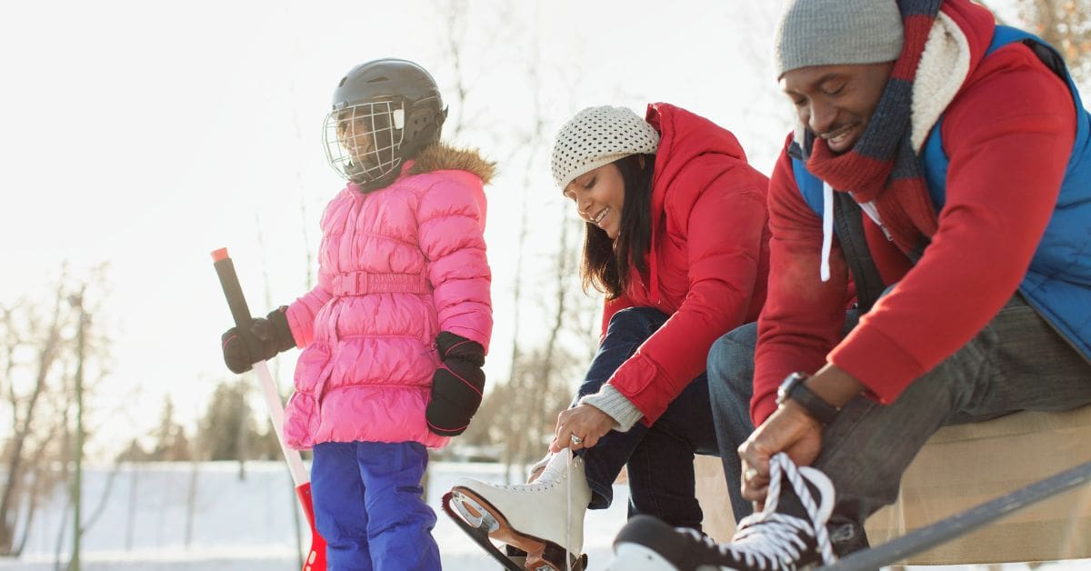A family is putting on skates at an outdoor rink during on the Family Day statutory holiday in Canada.