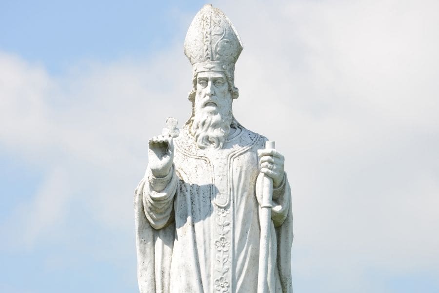 A stone statue of Saint Patrick standing at the Hill of Tara in Ireland, representing the origins of the holiday. 