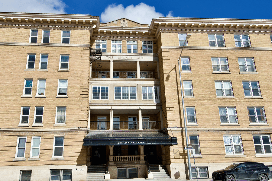 Exterior view of the historic Ambassador Manor (formerly Breadalbane) apartment building, a five-story yellow brick character block in downtown Winnipeg.