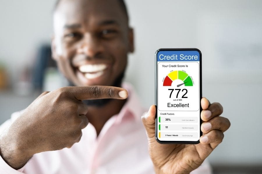 A newcomer holding a smartphone displaying an excellent Canadian credit score of 772 on a credit monitoring app.