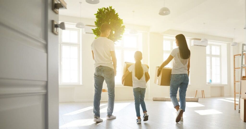 A young family is moving boxes into a new rental apartment. Knowing how to save money on rent is vital for newcomers to Canada.
