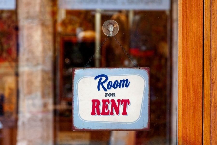 A sign hangs on a window that reads "room for rent". Home-sharing is a great way to save on rent and make local connections in Canada. 