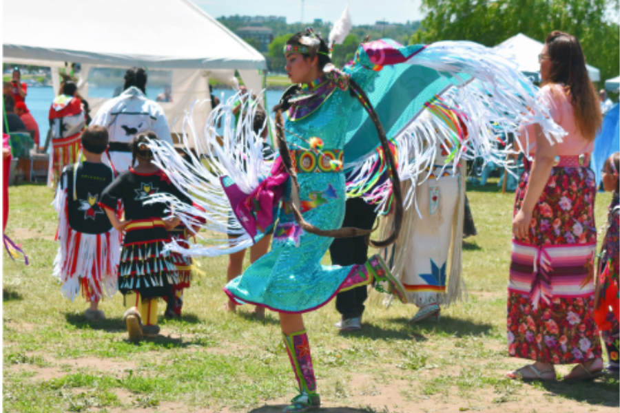 Indigenous peoples are dressed in traditional regalia at a powwow in Fredericton. 