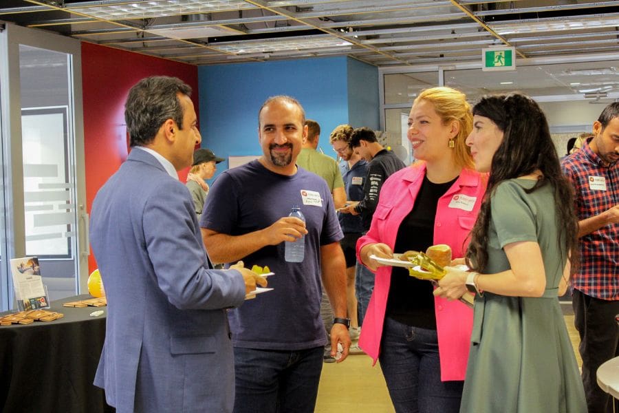 A group of professionals and entrepreneurs are engaged in discussion at a networking event.