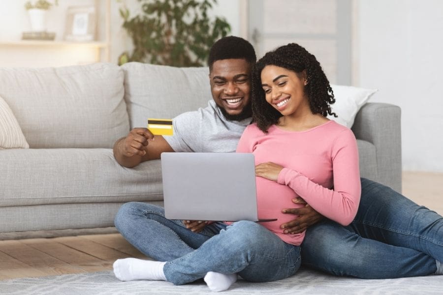 Young expectant parents are buying baby stuff online using a credit card.