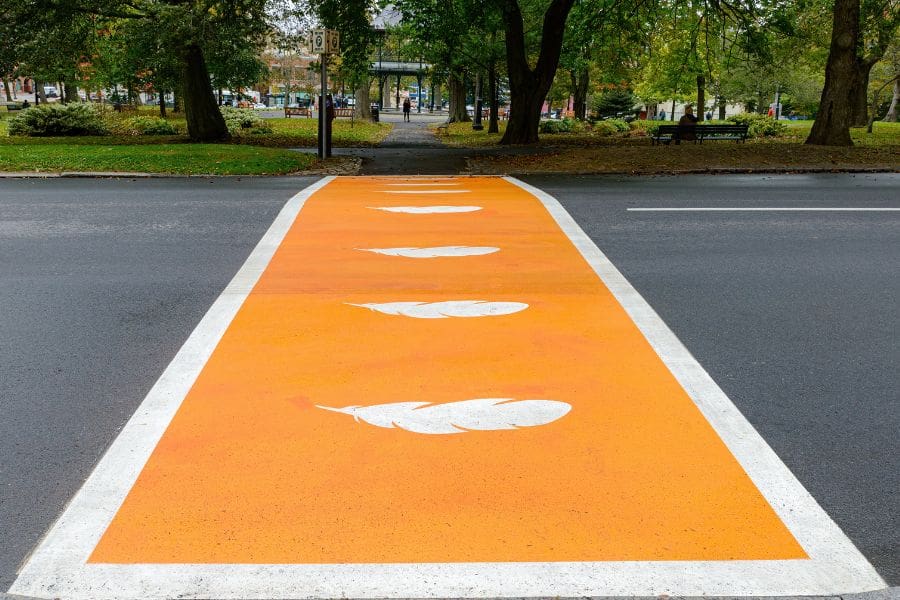 A crosswalk is painted orange with white feathers to honour the survivors of residential schools in Canada on the Day for National Truth and Reconciliation Day.