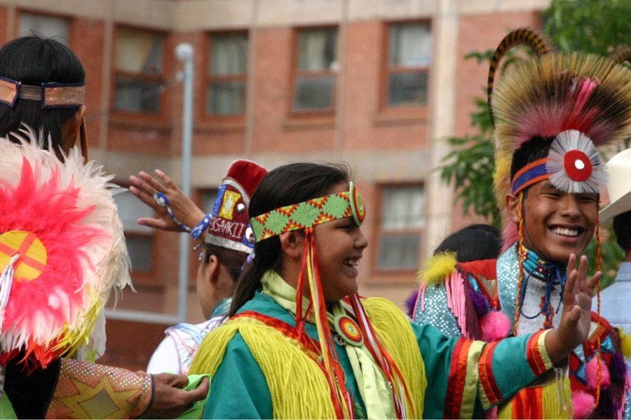 Indigenous children wearing traditional regalia at the Calgary Stampede in Alberta.