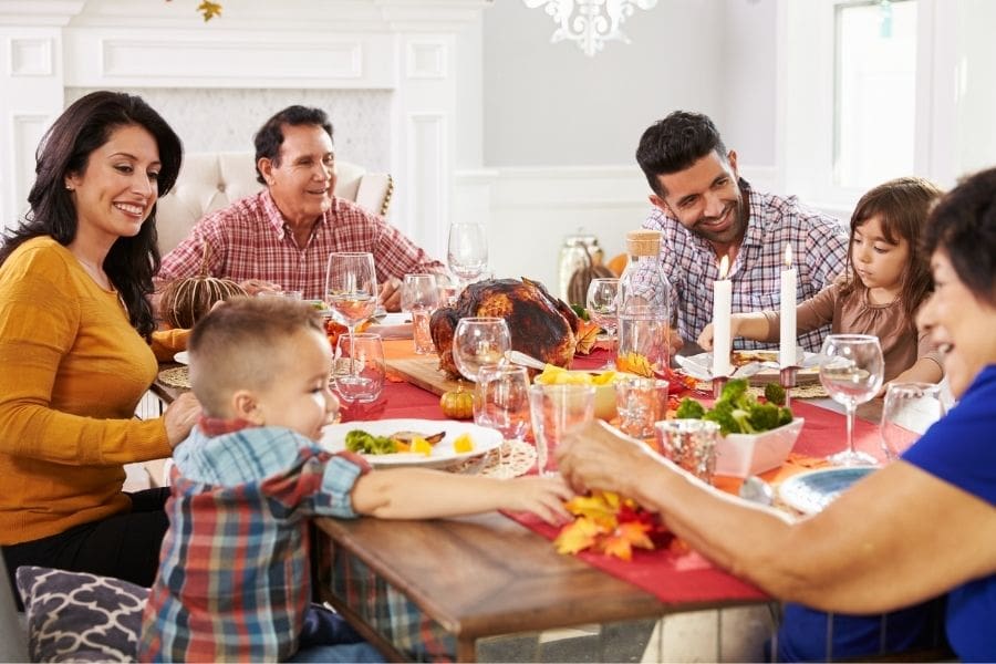 A family with grandparents are enjoying a Thanksgiving meal at the dinner table.