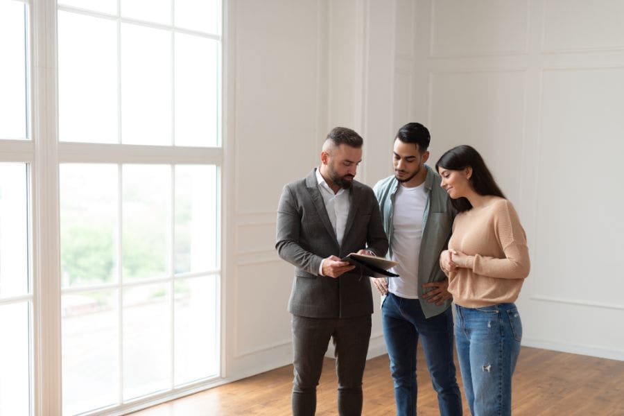 A young couple is looking for apartments for rent in Ottawa and discussing the rental application with a landlord. 