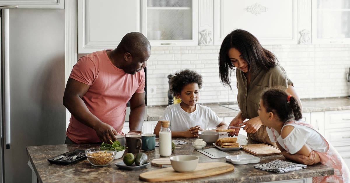 A young newcomer family is cooking dinner together to manage the cost of living in Canada.
