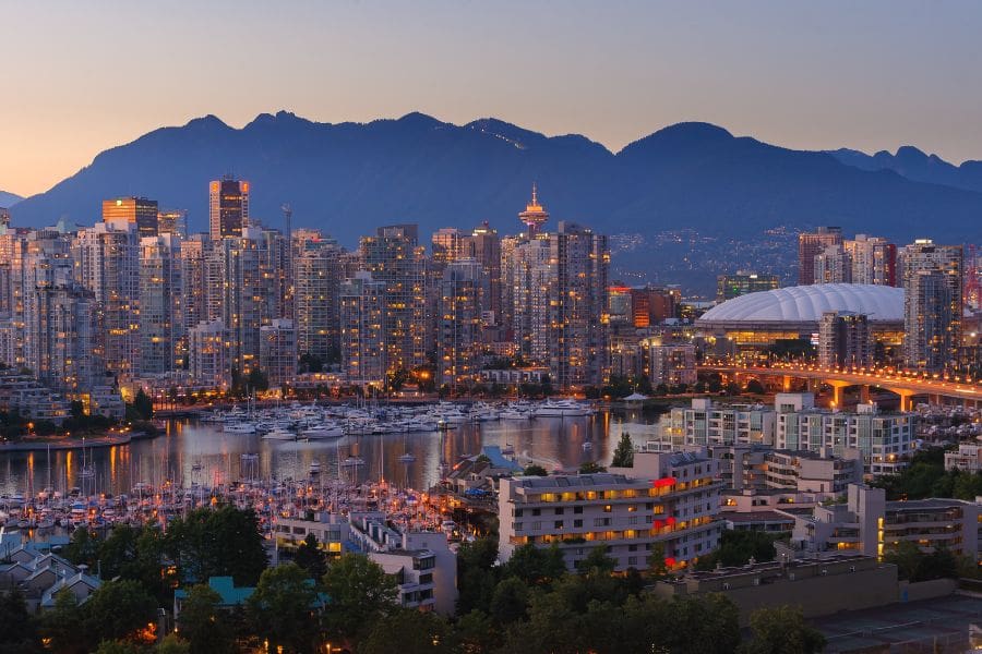 Vancouver skyline at twilight with mountains in the background.