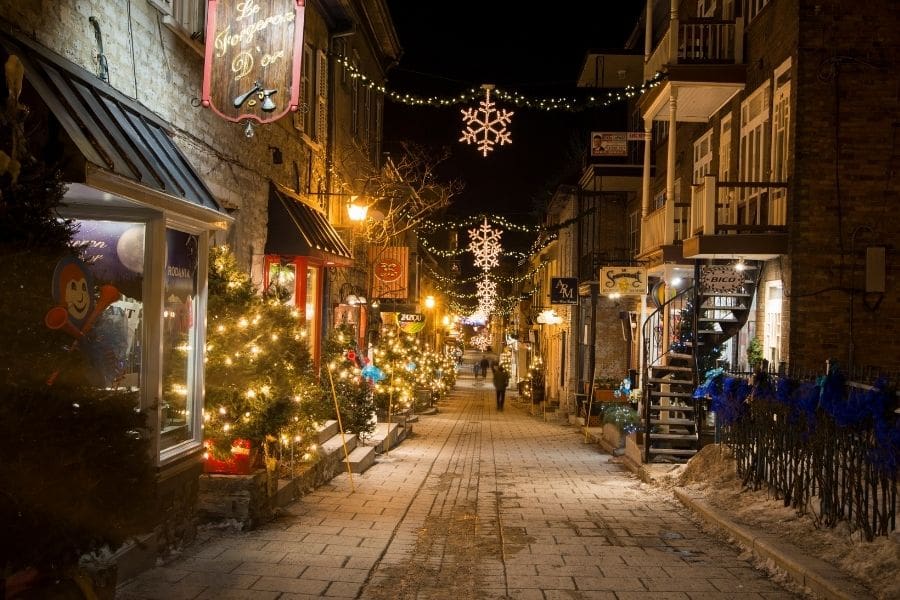 Historic buildings in Old Québec City decorated with Christmas lights on a winter night, showcasing architecture and holiday ambiance, 2025.
