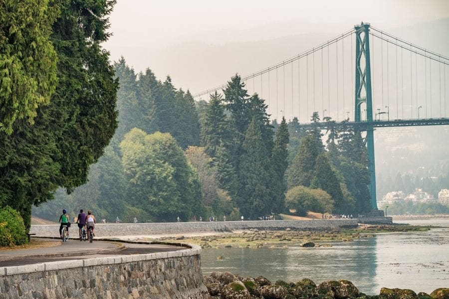 Cyclist riding along the Stanley Park Seawall near English Bay, representing one of the best places to live in Vancouver.