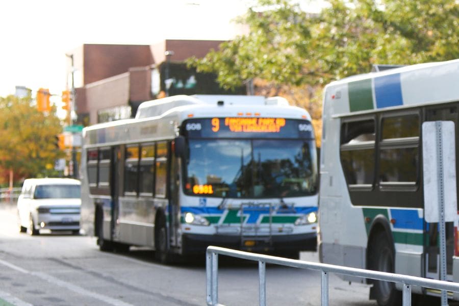 London Transit bus driving through London, Ontario, with passengers and city streets.