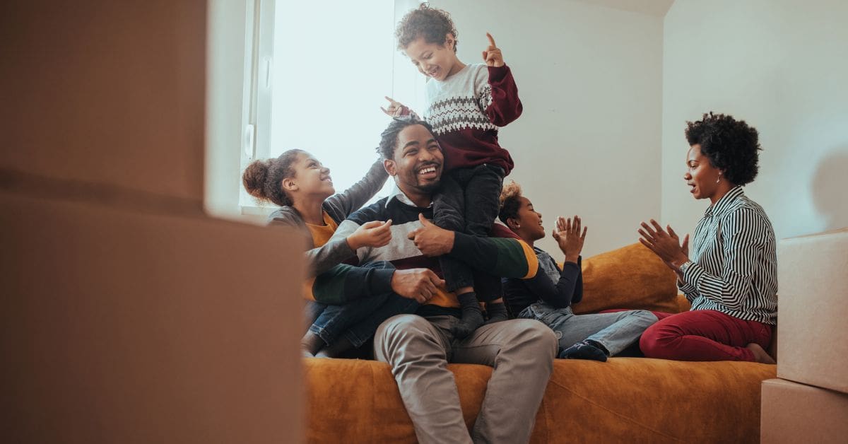 Parents and their children are playing on a sofa after moving into a family-friendly rental apartment in Canada.