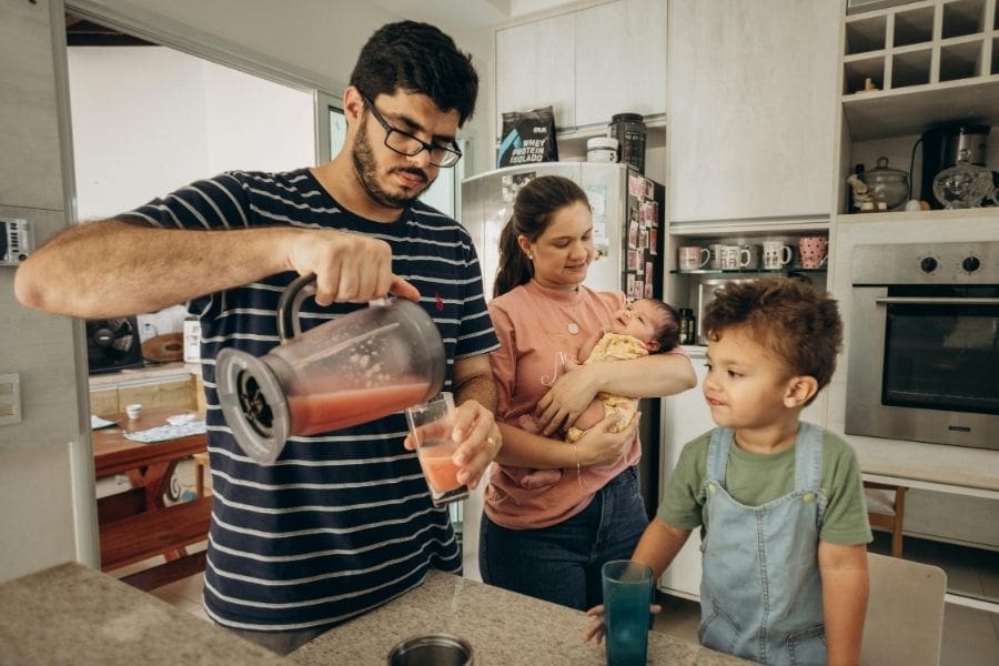 Young father and family preparing food together in a family-friendly apartment.