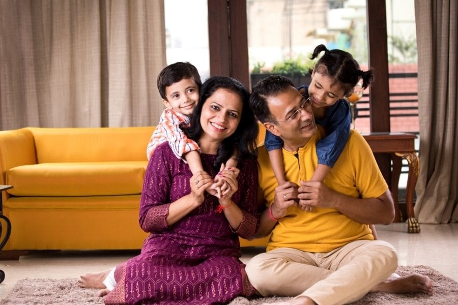 Young Indian family relaxing together in their new rental apartment after learning how to choose an apartment in Canada