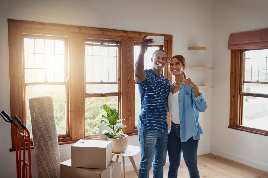 Young couple standing inside their first home and achieving their home ownership goals in Canada.