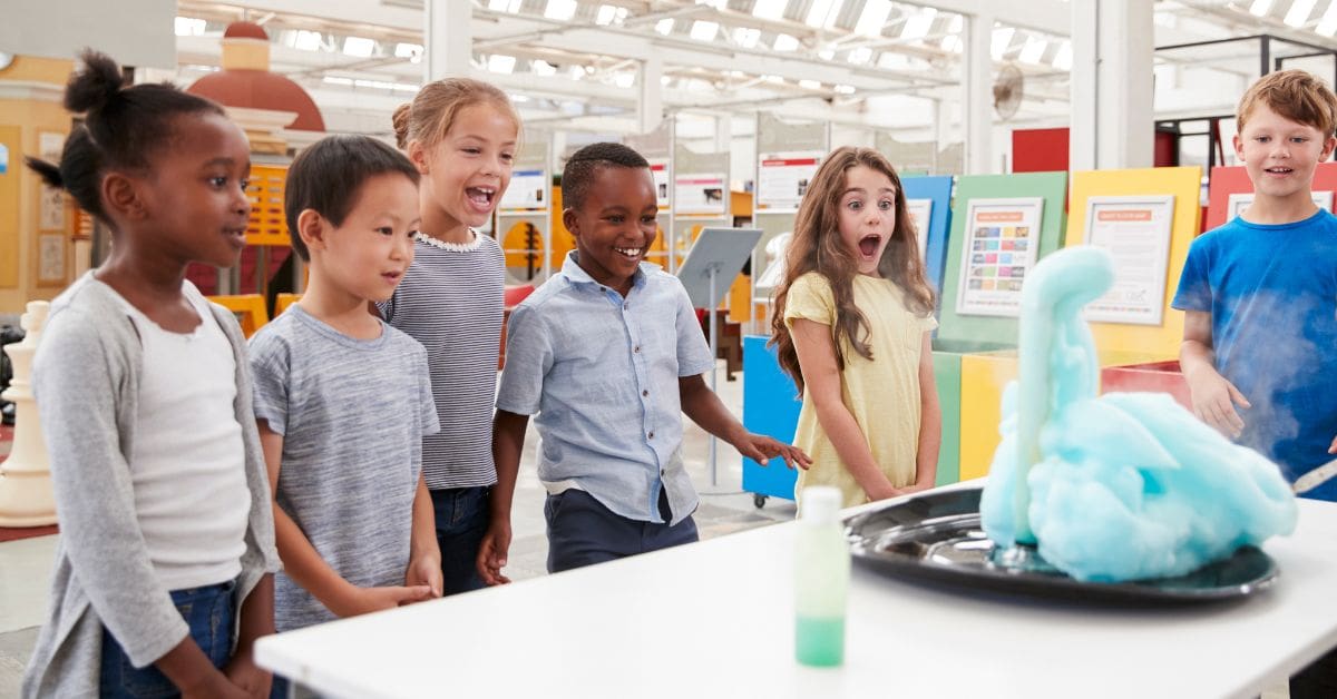 Kids having fun watching an experiment at a science center during March Break in Canada.