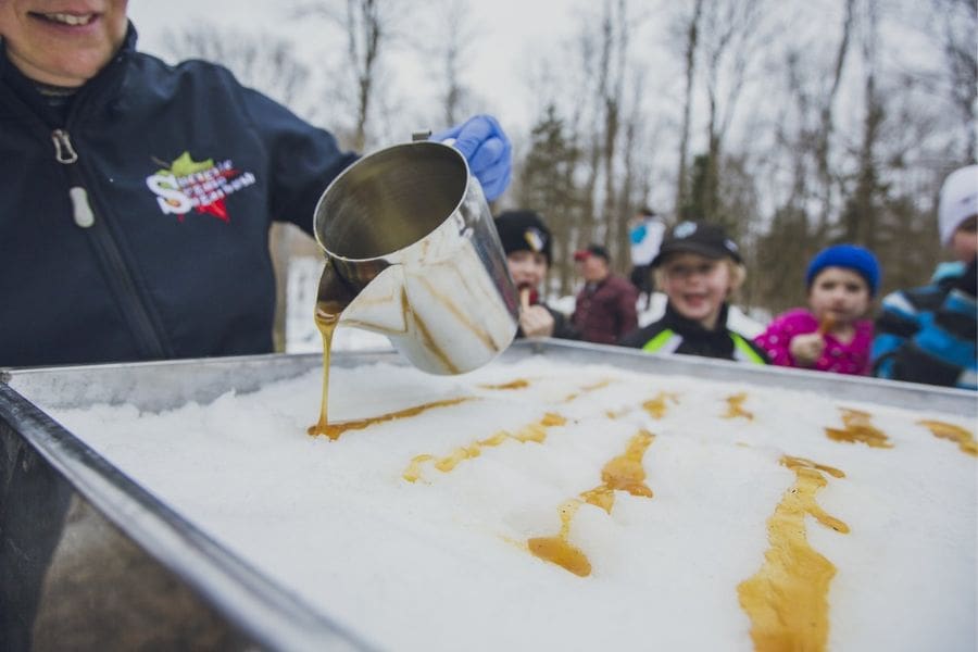 Children are visiting a sugar shack during maple syrup season in Ontario in March.