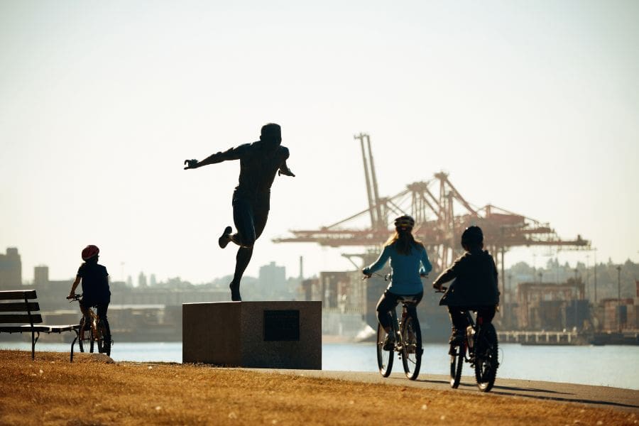 Family cycling along the Stanley Park seawall in Vancouver during early spring.