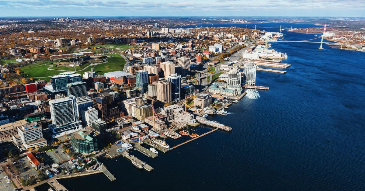 Halifax waterfront skyline featuring Purdy's Wharf and a historic tall ship in the harbour.
