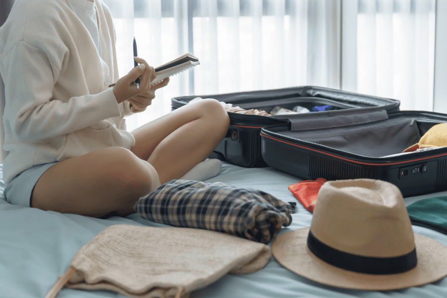 Person packing a suitcase and making a checklist before moving to Canada