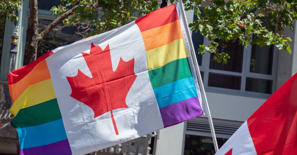 Canada Pride 2026 newcomer guide featured image: A hybrid Canadian flag with a red maple leaf over a rainbow background.