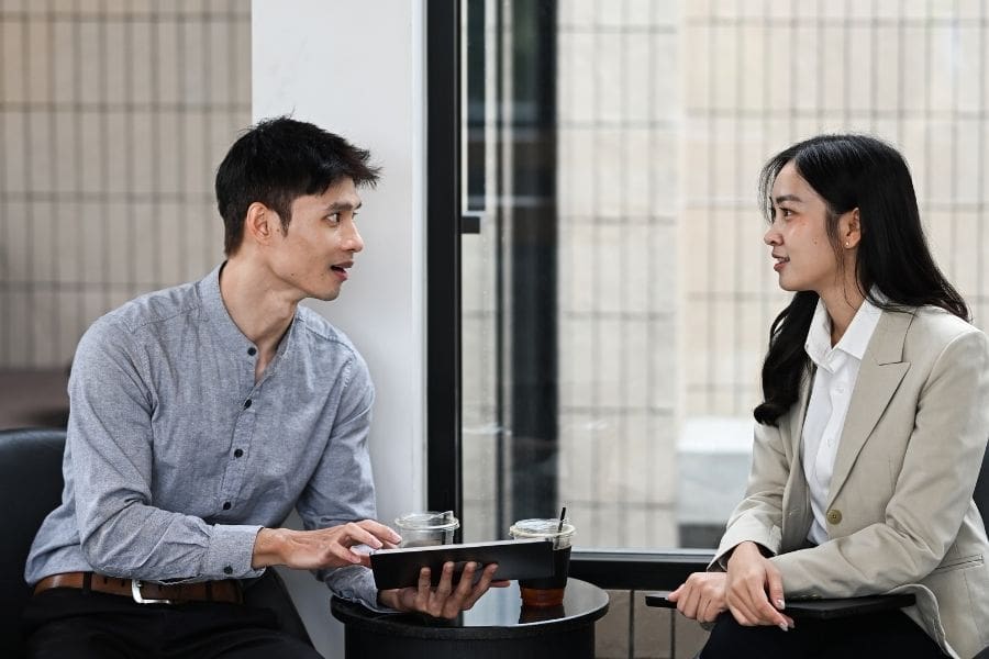 Friendly personal banking advisor speaking with a newcomer in Canada during an introductory meeting.