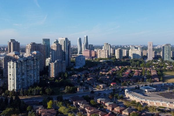 Panoramic aerial view showing suburban low-rise residential homes in the foreground and mid- and high-rise apartments downtown.