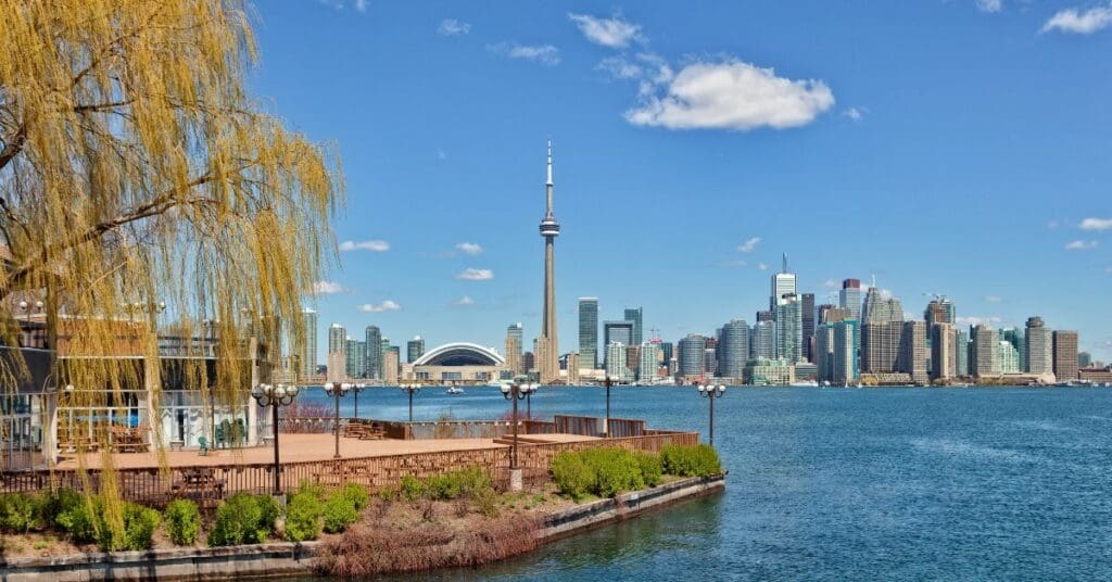 Scenic view of the Toronto city skyline and CN Tower across Lake Ontario, showcasing the beautiful waterfront and outdoor lifestyle of those living in Toronto.