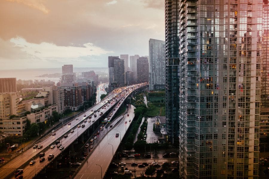 Heavy commuter traffic on the Gardiner Expressway passing through downtown condo towers, highlighting the daily driving and traffic reality for residents living in Toronto.