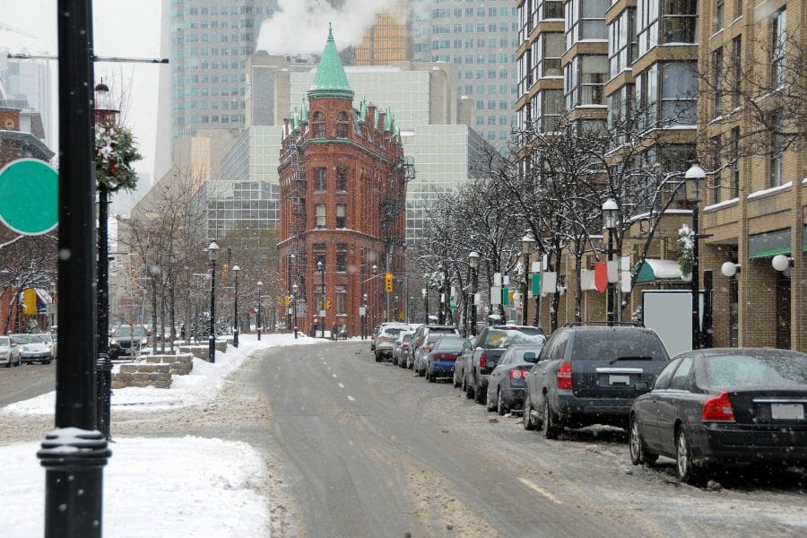 The historic Gooderham Flatiron building in Toronto surrounded by snow and winter slush, highlighting the beautiful but cold winter climate for those living in Toronto.