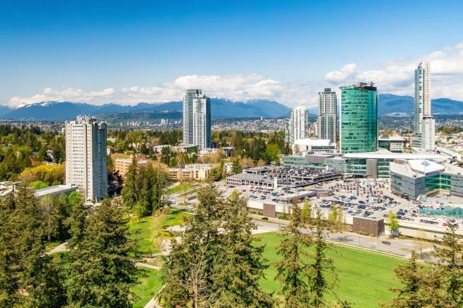 Aerial view of high-rise apartment buildings, green parks, and the SFU campus in Surrey City Centre, Metro Vancouver, British Columbia.