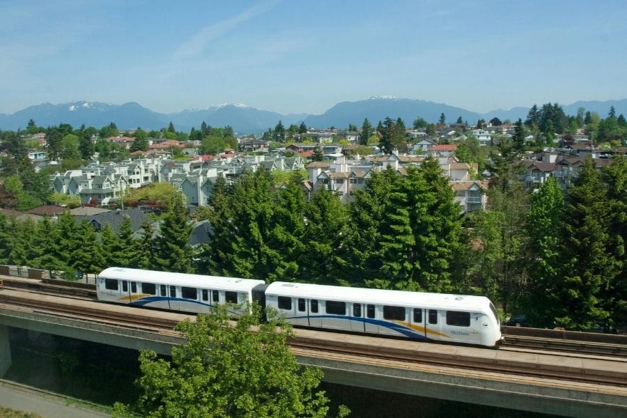 A TransLink SkyTrain traveling along elevated tracks, making getting around easy for newcomers living in Vancouver.
