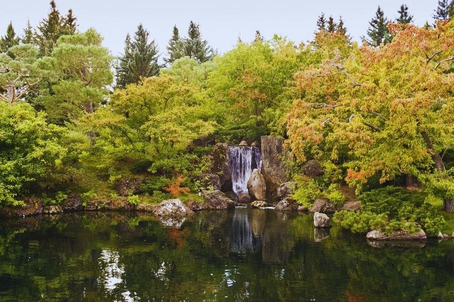 A peaceful waterfall at Nikka Yuko Japanese Garden highlighting local attraction options when living in Lethbridge.