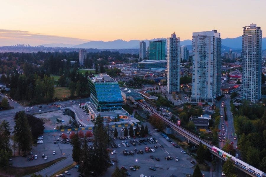 Aerial view of high-rise apartment towers, SkyTrain tracks, and civic buildings in Whalley, Surrey City Centre BC.